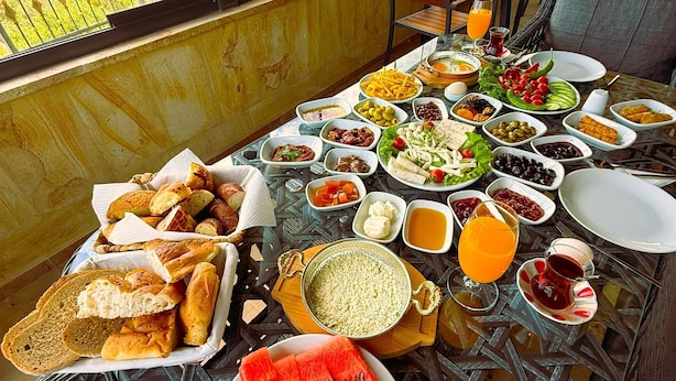 Uma mesa posta com diversos pratos e vista para as montanhas.