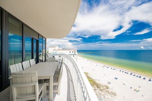 Uma varanda com vista para uma praia e um cais.