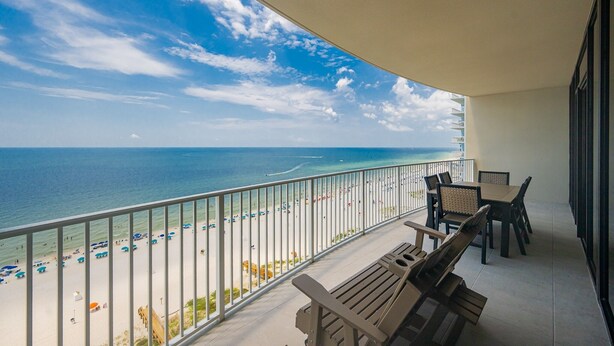 A balcony with a view of a beach and ocean.