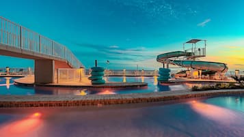 Een waterpark met een brug, glijbanen en een zwembad.