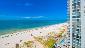 A beach view with a hotel building on the right.