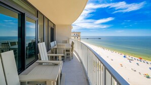 A balcony with a view of a beach and pier.
