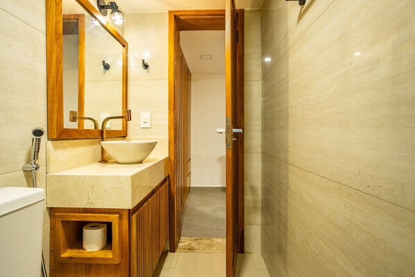 Une salle de bain avec un meuble-lavabo en bois, un grand miroir et un lavabo.