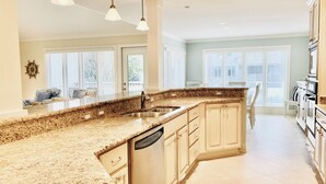 A kitchen with granite countertops, stainless steel appliances, and a large island with a sink. - 40 Turtle Lane at The Sea Pines Resort (Hilton Head Island)