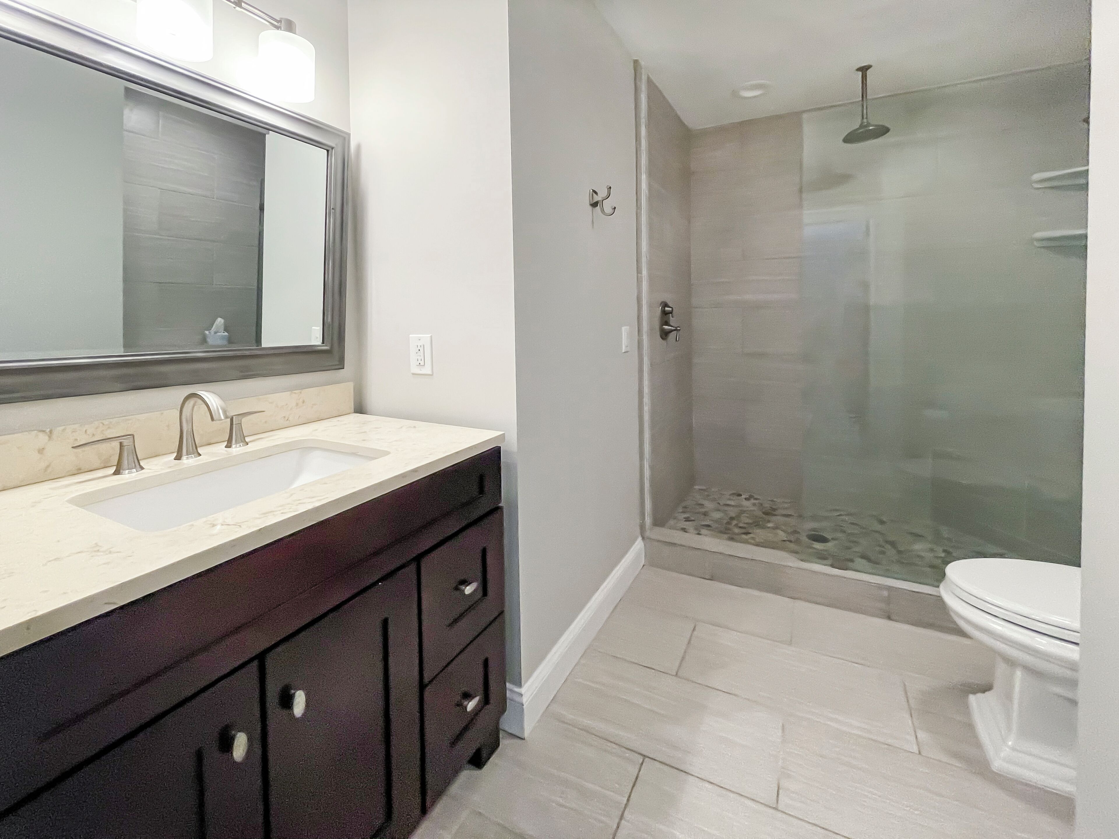 Une salle de bain moderne avec un meuble-lavabo à deux vasques, une douche à parois de verre et des toilettes.