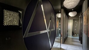 A modern hallway with a large abstract sculpture, geometric wall art, and contemporary light fixtures. - Vip garden and jacuzzi seaview in the hearth of downtown (La Spezia)