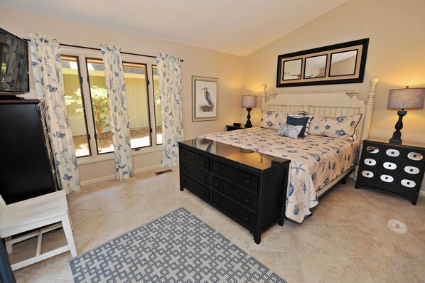 A bedroom with a bed, a dresser, a TV, and a window with curtains. - 41 Deer Run Lane at The Sea Pines Resort (Hilton Head Island)