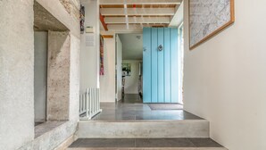 Un escalier menant à une pièce dotée d’une porte bleue, d’une balustrade blanche et d’un mur en marbre.