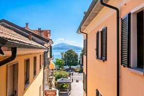 Eine schmale Straße mit Gebäuden, einem Restaurantschild und einem Berg im Hintergrund.