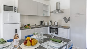 A modern kitchen with white cabinets, a built-in microwave, and a gas stove. - Nel Cuore Di Baveno 50m from Lake (Baveno)