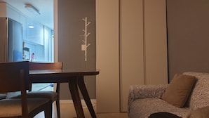 A modern living room with a dining area, featuring a sofa, a dining table, and a chair.