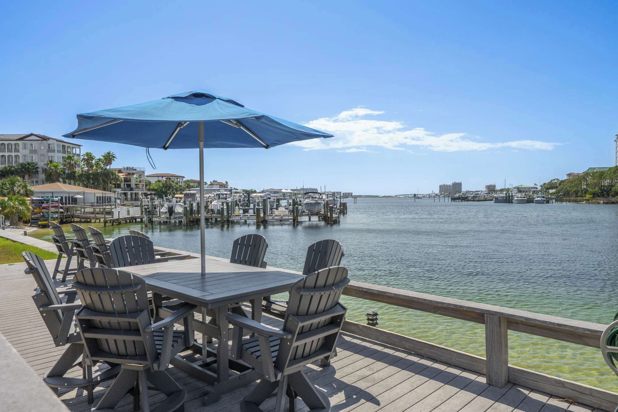 A waterfront deck with outdoor seating and a view of the marina.