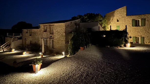 A stone building with a gravel driveway and potted plants. - Mas d'Eyrolles (Sainte-Anastasie)