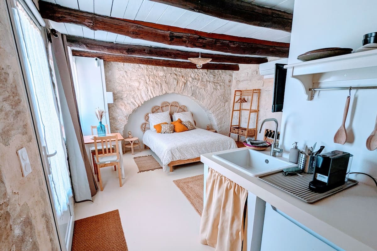 Un dormitorio con cama, mesita de noche y lavamanos integrado.