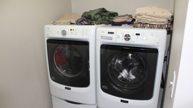 Two front-loading washing machines in a laundry room.
