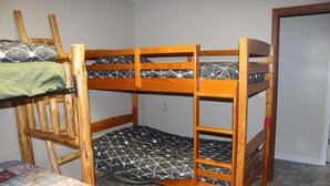 A bunk bed with a wooden frame and patterned bedding.