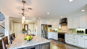A modern kitchen with white cabinetry, stainless steel appliances, and a granite countertop. - 213 Twin Oaks at The Sea Pines Resort (Hilton Head Island)