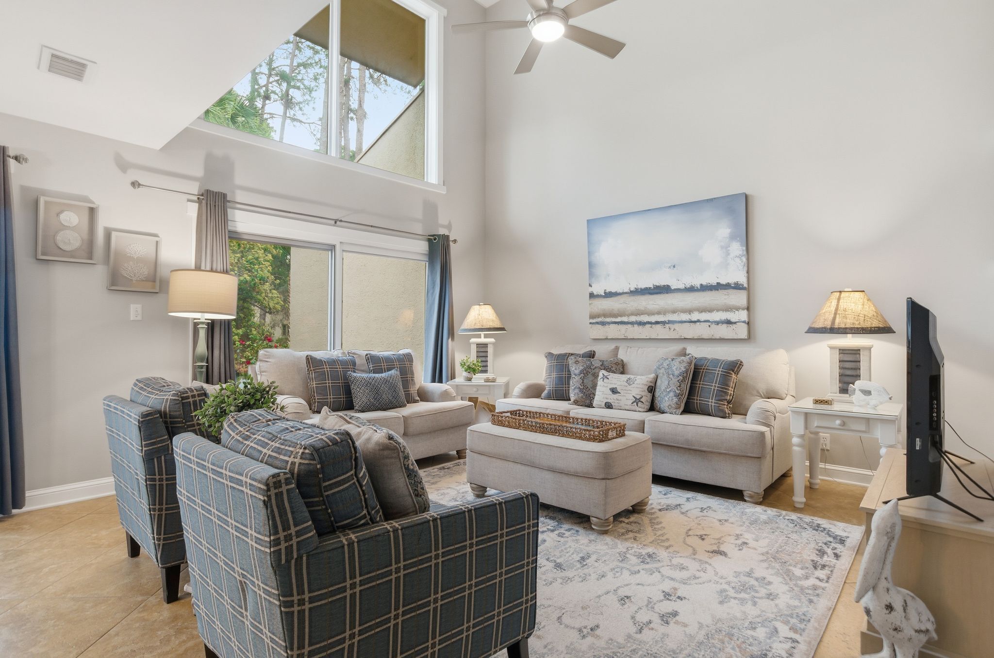 A living room with a sofa set, a coffee table, a TV, and a painting on the wall.