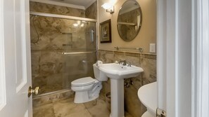 A bathroom with a glass-enclosed shower, a pedestal sink, and a toilet. - 153 Harbourwood Villa at The Sea Pines Resort (Hilton Head Island)