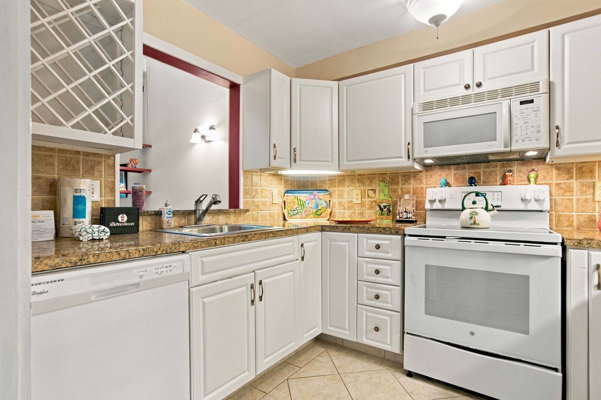 A kitchen with white cabinets, a built-in microwave, and a dishwasher.