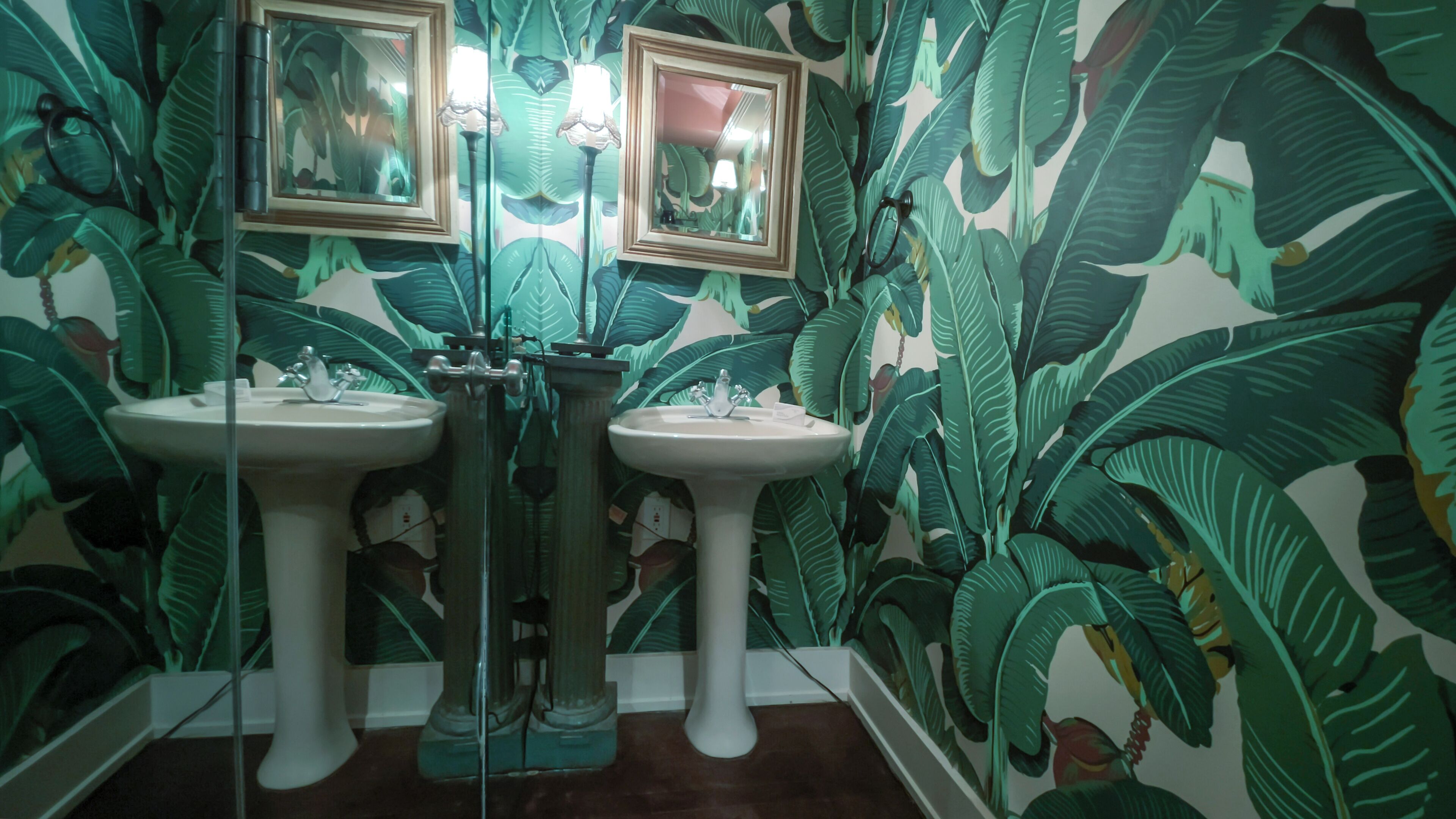 A bathroom with two sinks, mirrors, and a shower.