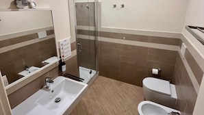 A modern bathroom with a glass-enclosed shower, a large sink, a bidet, and a toilet. - de Ribera rooms (Naples)