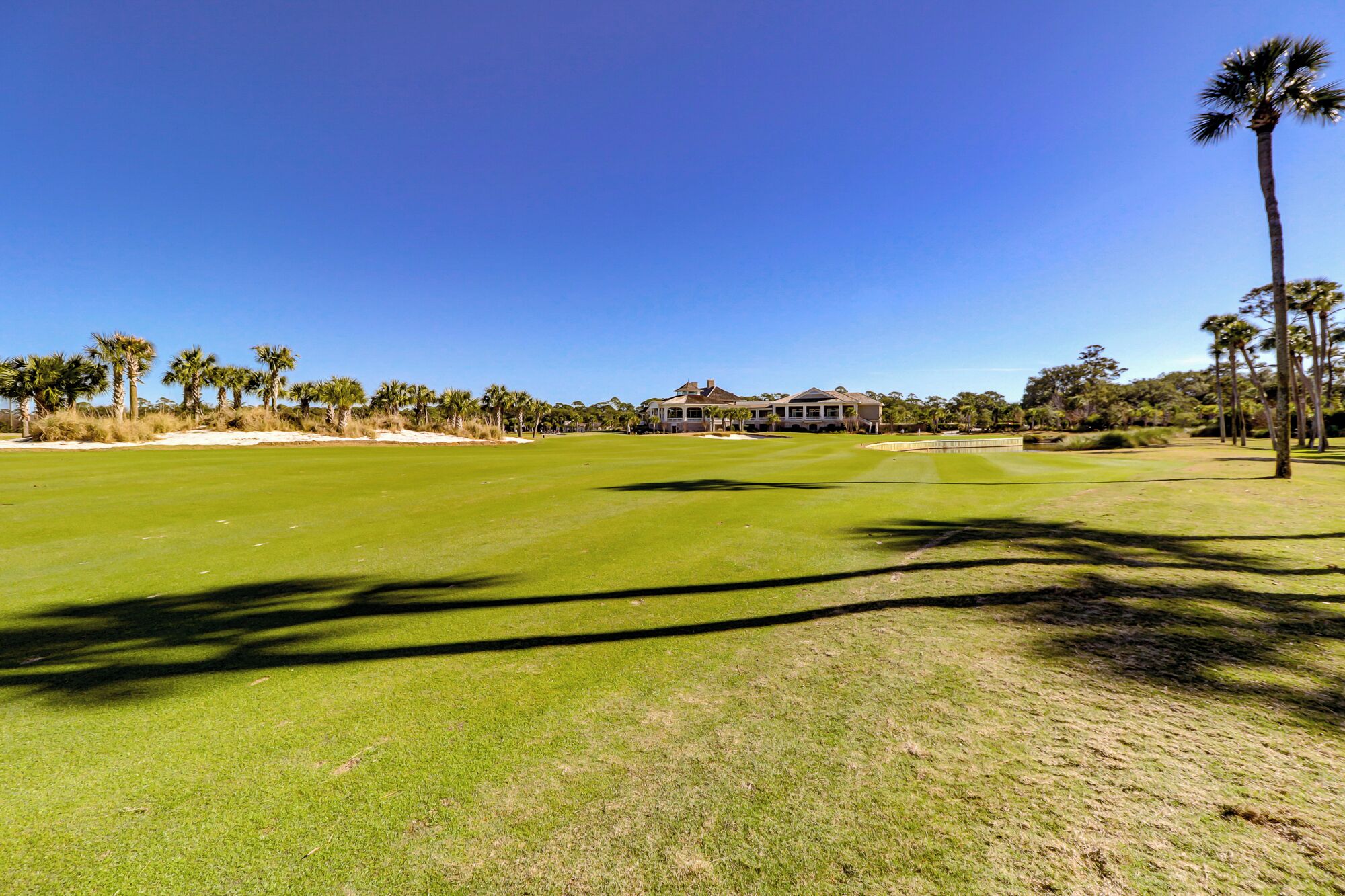 Ein Golfplatz mit einem Clubhaus im Hintergrund.
