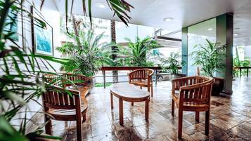 A spacious indoor area with wooden furniture and potted plants.
