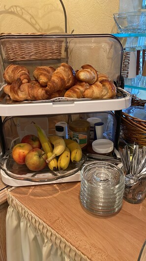 Un buffet de petit-déjeuner avec des croissants et des fruits.