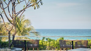 A seaside terrace with two wicker chairs and a table, overlooking the ocean. - Ocean Sun Pool Villas Resort Cam Ranh (Cam Lam)