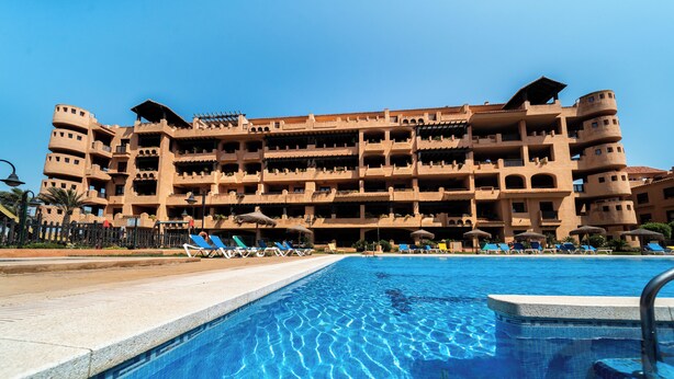 A hotel with a large pool, multiple balconies, and sun loungers. - DREAM SEA APARTMENTS - 1 BEDROOM (El Ejido)