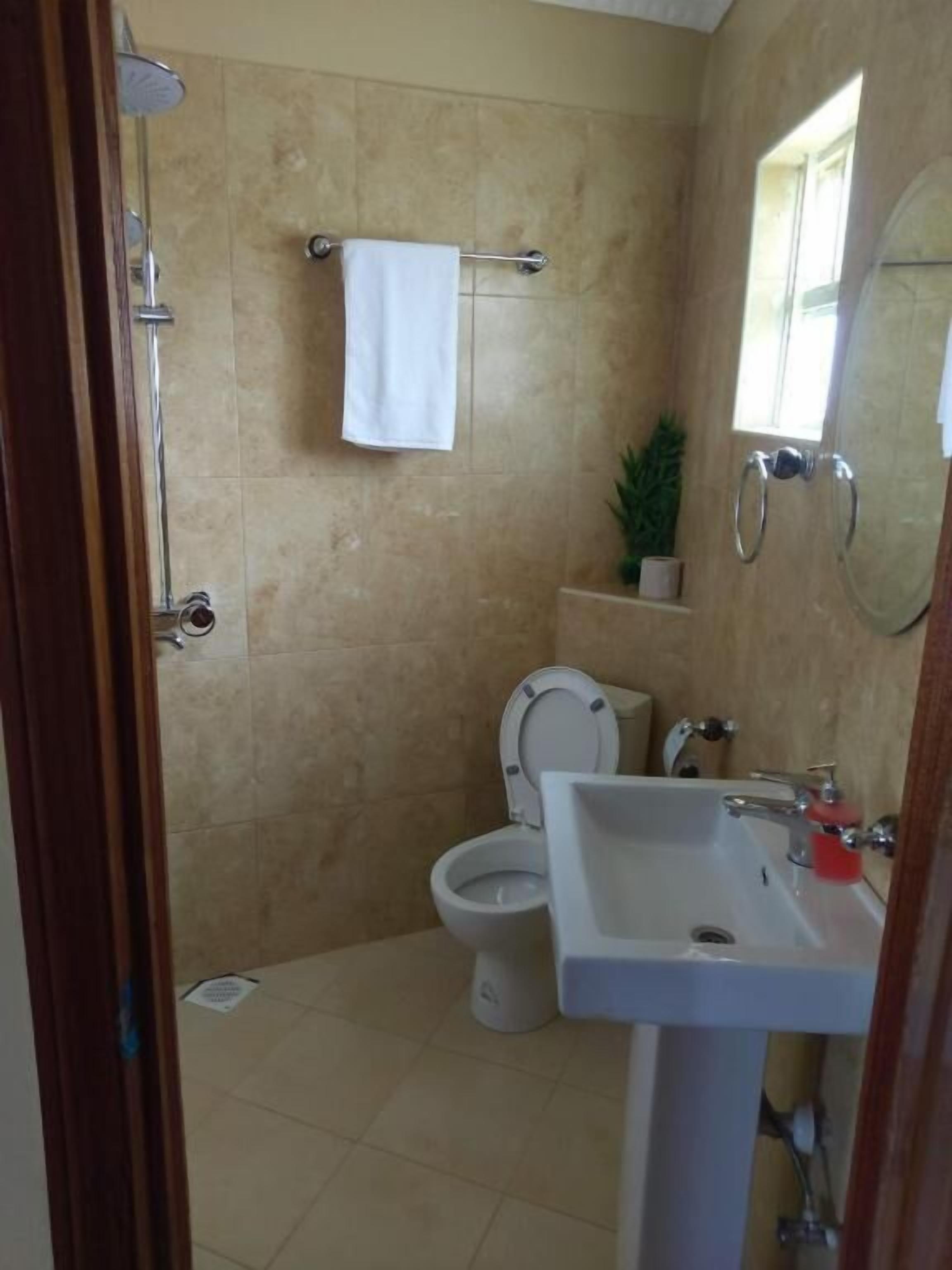 A bathroom with a toilet, sink, and shower.