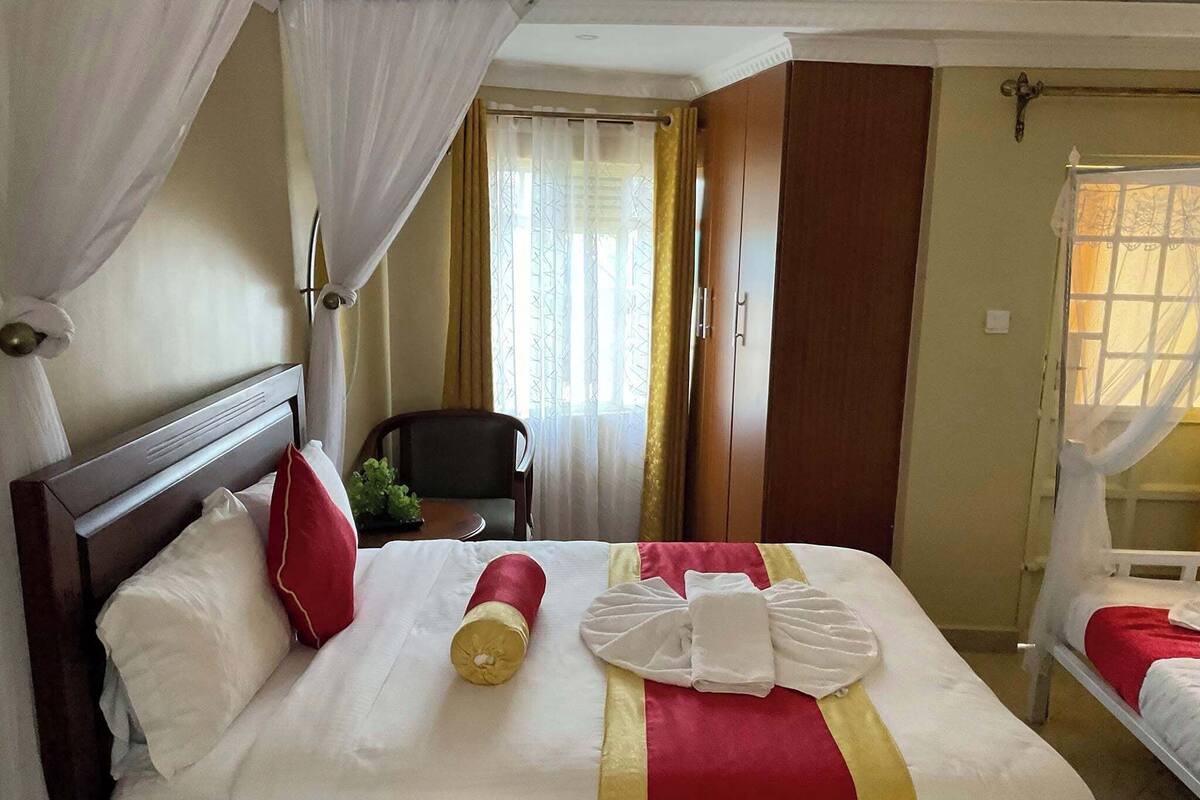 Une chambre d’hôtel avec un lit, une chaise, une fenêtre et une porte.