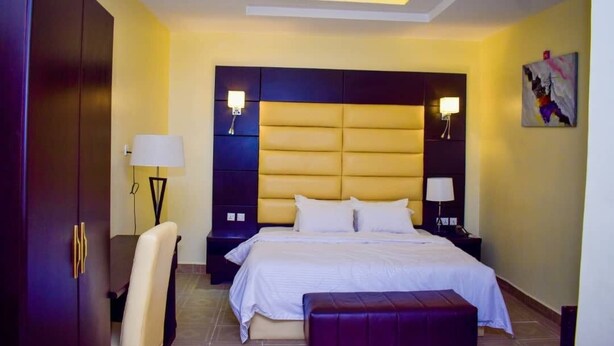 Een hotelkamer met een groot bed, een bureau, een stoel en een kledingkast.