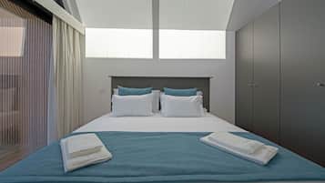 Una habitación de hotel moderna con una cama grande, vistas del cielo a través del techo y un armario.