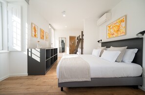 Un dormitorio con una cama, un escritorio y una escalera.