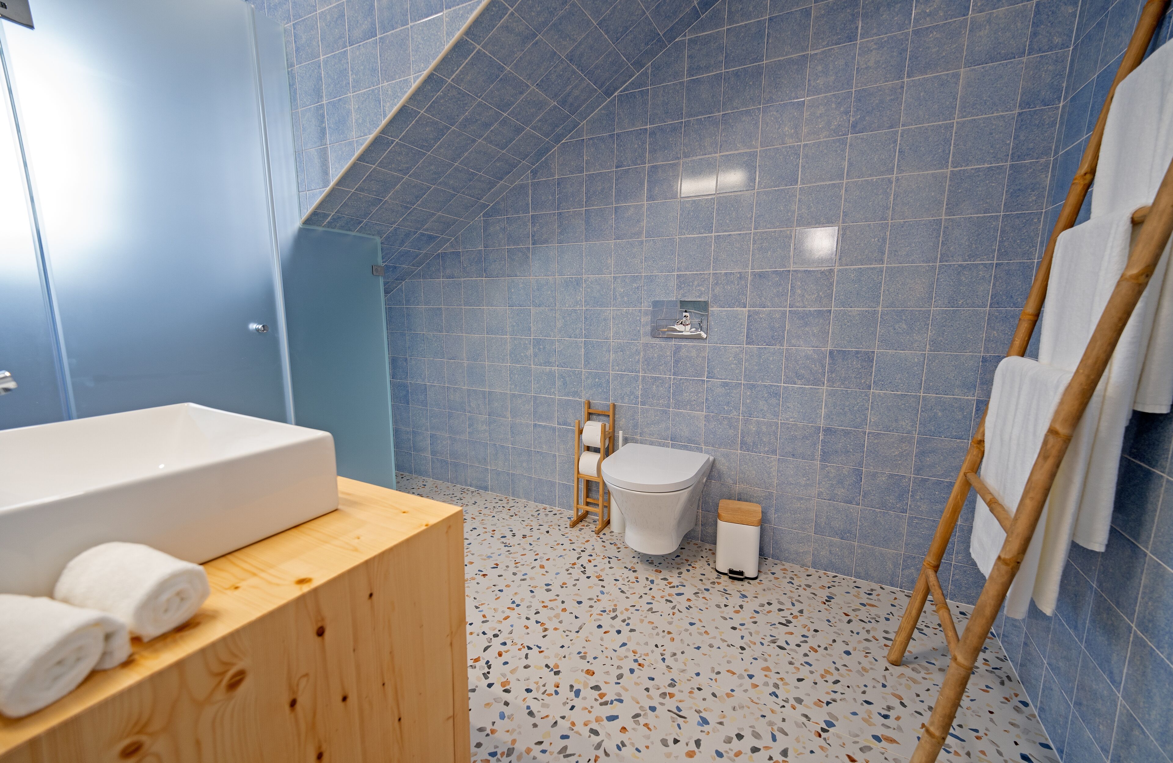 Un baño con una bañera blanca, inodoro y zona de ducha.