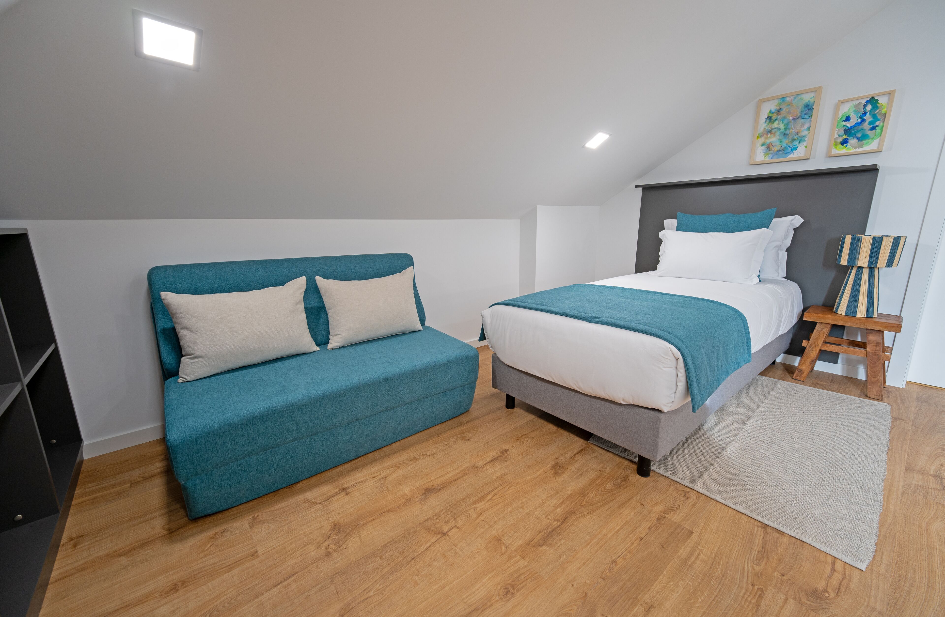 Quarto moderno com cama, sofá e uma mesinha.