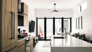 A modern kitchen with wooden cabinets, a large island, and a ceiling fan.