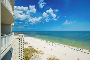 Un hotel frente a la playa con balcón con vistas a la playa y al océano.