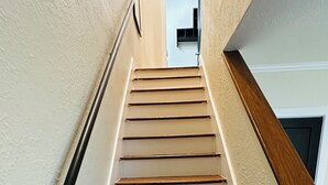 A staircase with wooden steps and white walls. - Charming 2-Bedroom Condo in Baton Rouge close to LSU and Downtown (Baton Rouge)