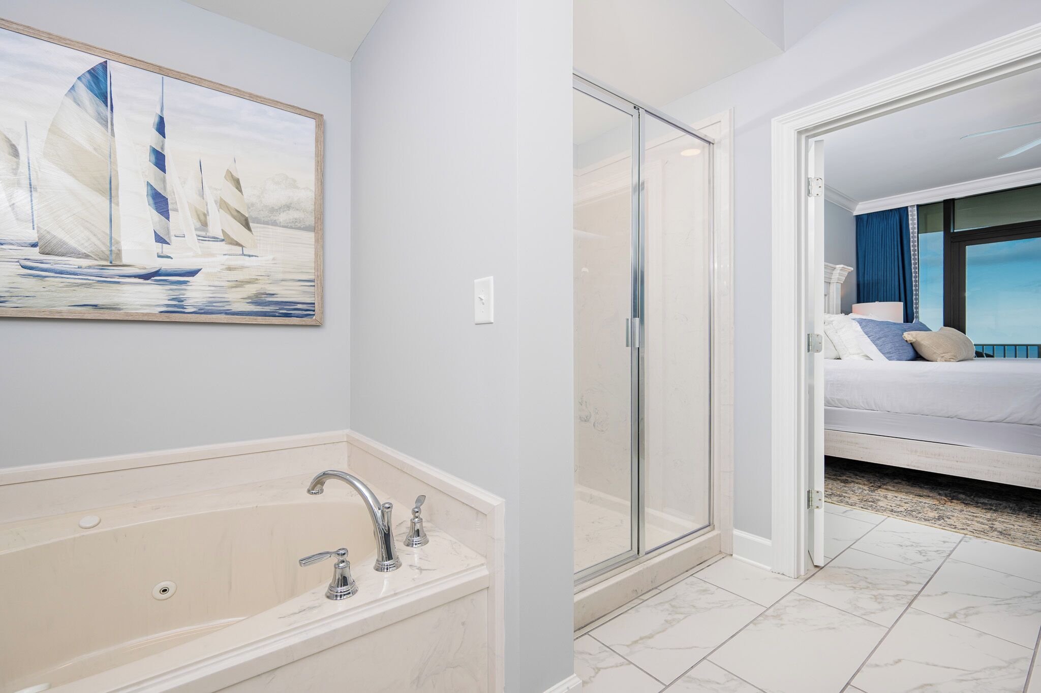 Une salle de bain moderne avec une baignoire, une douche à l’italienne en verre, et une chambre avec un lit et une vue.