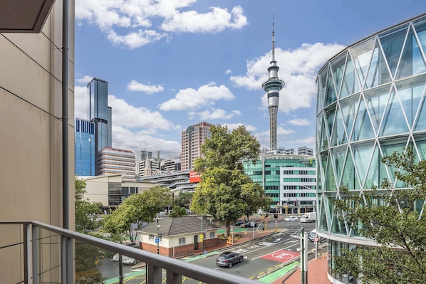 Un paisaje urbano con edificios modernos, una torre destacada y una estructura de vidrio.