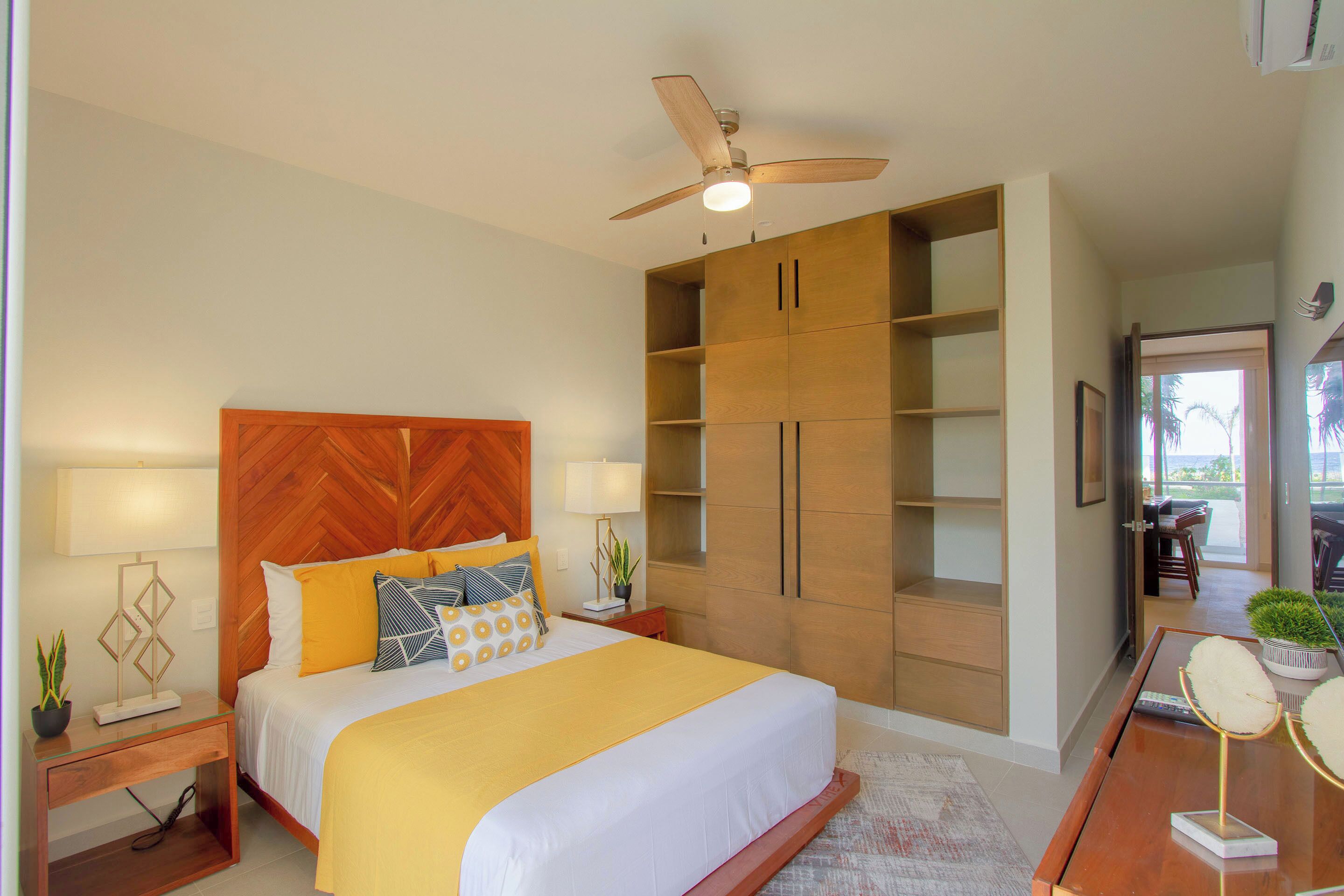 Ein Hotelzimmer mit einem großen Bett, einem Holz-Kopfteil und integrierten Regalen.