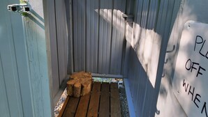 A wooden deck with a metal chain overhead, a wooden bench, and a sign that reads "PLEASE OFF WHEN". - Small family & pet friendly campground. Easy access to many public beaches. (Hartington)