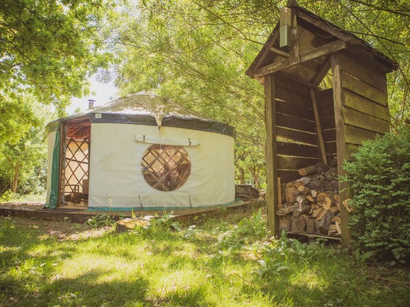 A yurt with a circular window and a small wooden structure nearby. - Brandon House Farm Yurt (Norwich)