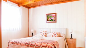 A bedroom with a bed, nightstands, a framed picture, and a window with curtains. - Complejo 21 de Enero - Luz y Fuerza (Puerto Madryn)