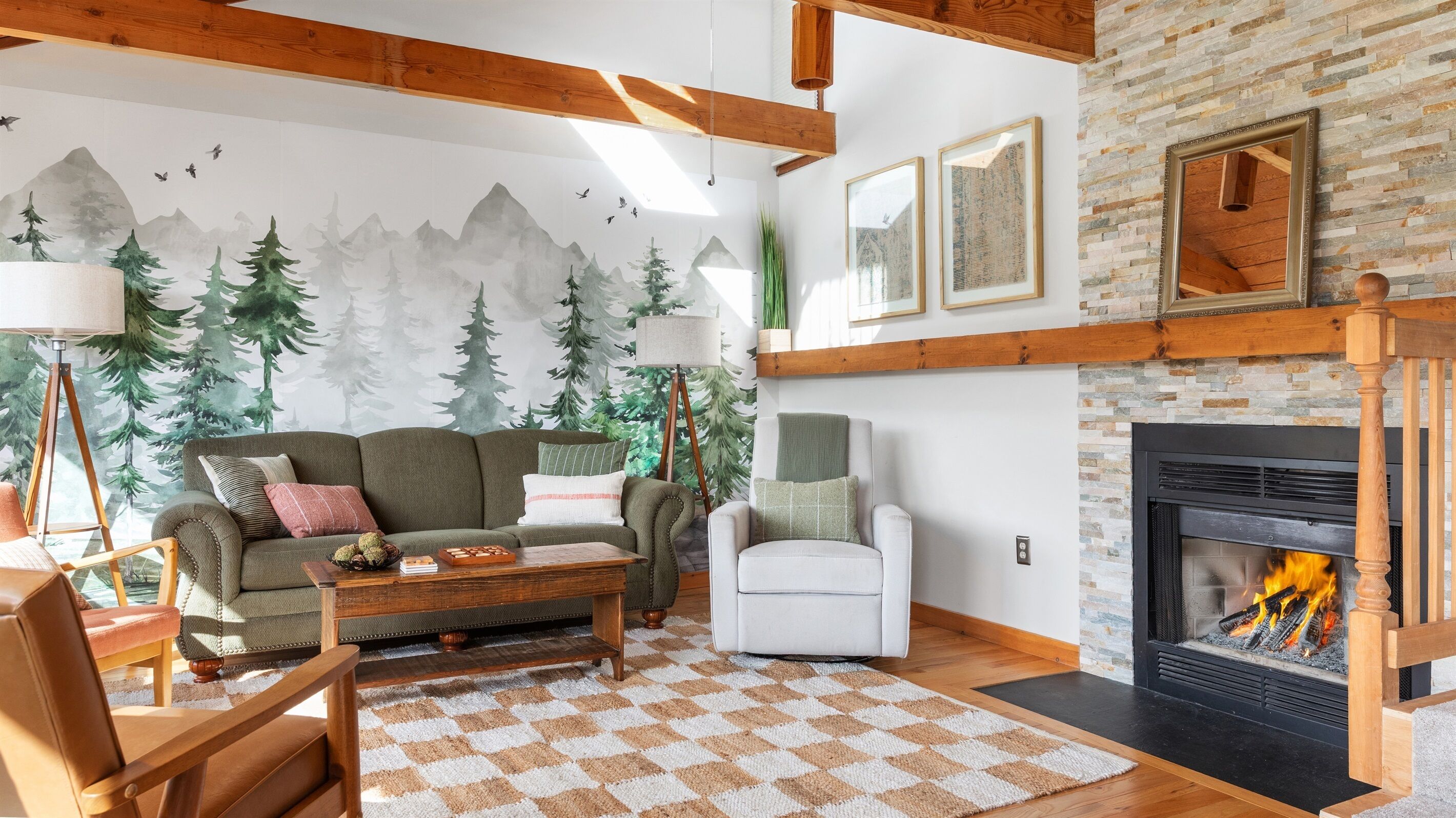 A cozy living room with a fireplace, a sofa, armchairs, and a patterned rug.