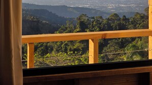 Un balcon en bois offrant une vue sur le paysage urbain et les montagnes.