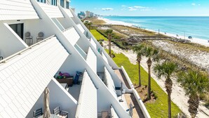 A beachfront hotel with a sloped roof, outdoor seating, and a view of the beach and ocean. - Aegean 214 Gorgeous 2 bed/2 bath (Destin)